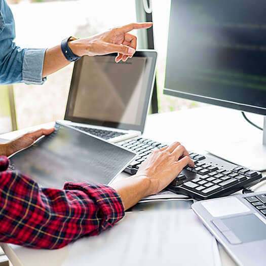 Office workers using a computer and laptop